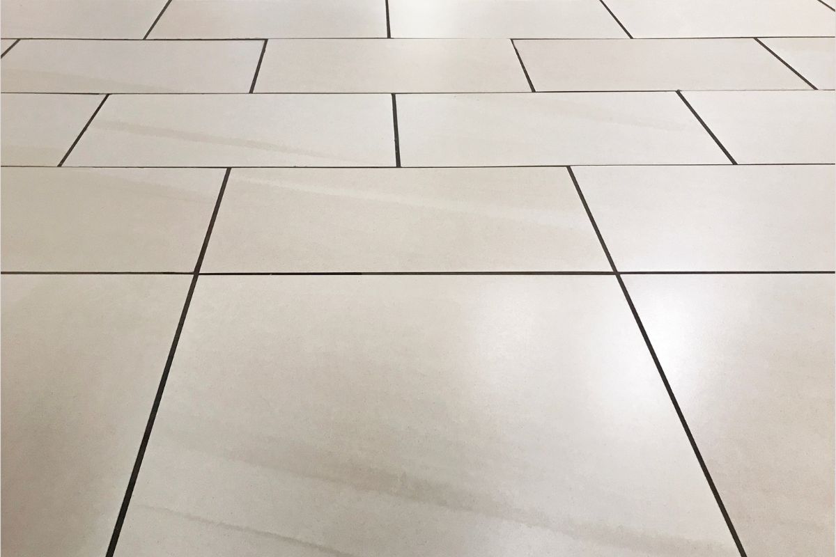  A pristine white tile floor, reflecting light, creating a seamless and elegant appearance throughout the space.