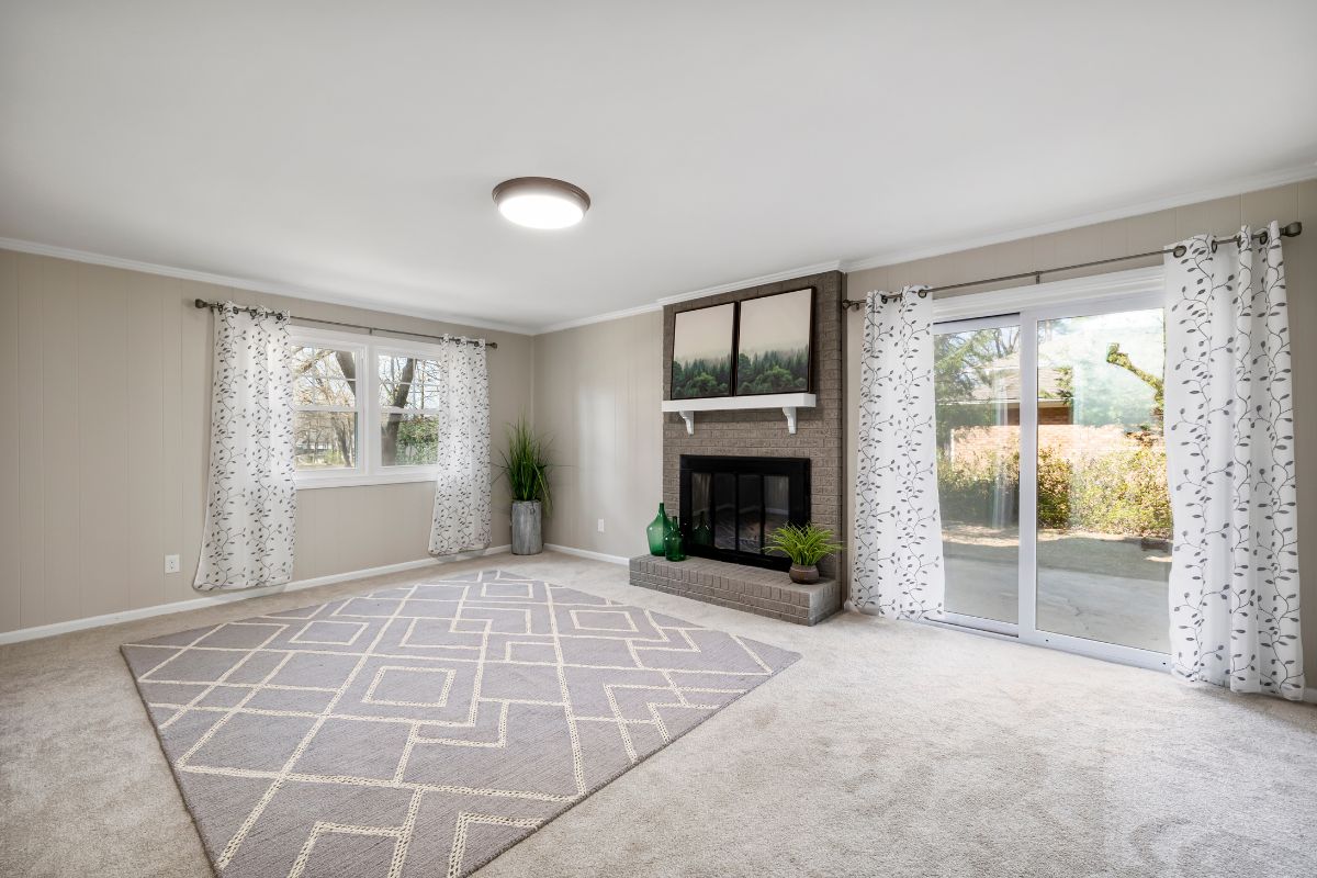 A spacious living room featuring tile flooring and large windows that allow ample natural light to enter the space. 